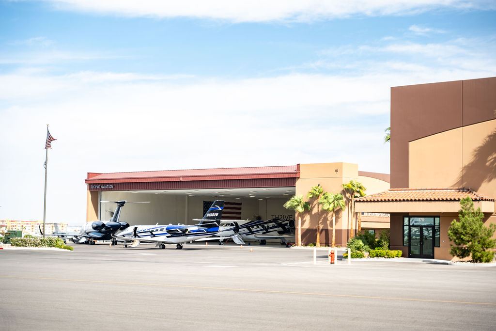 two planes in front of a hanger and one inside at Quail Air Center in Las Vegas