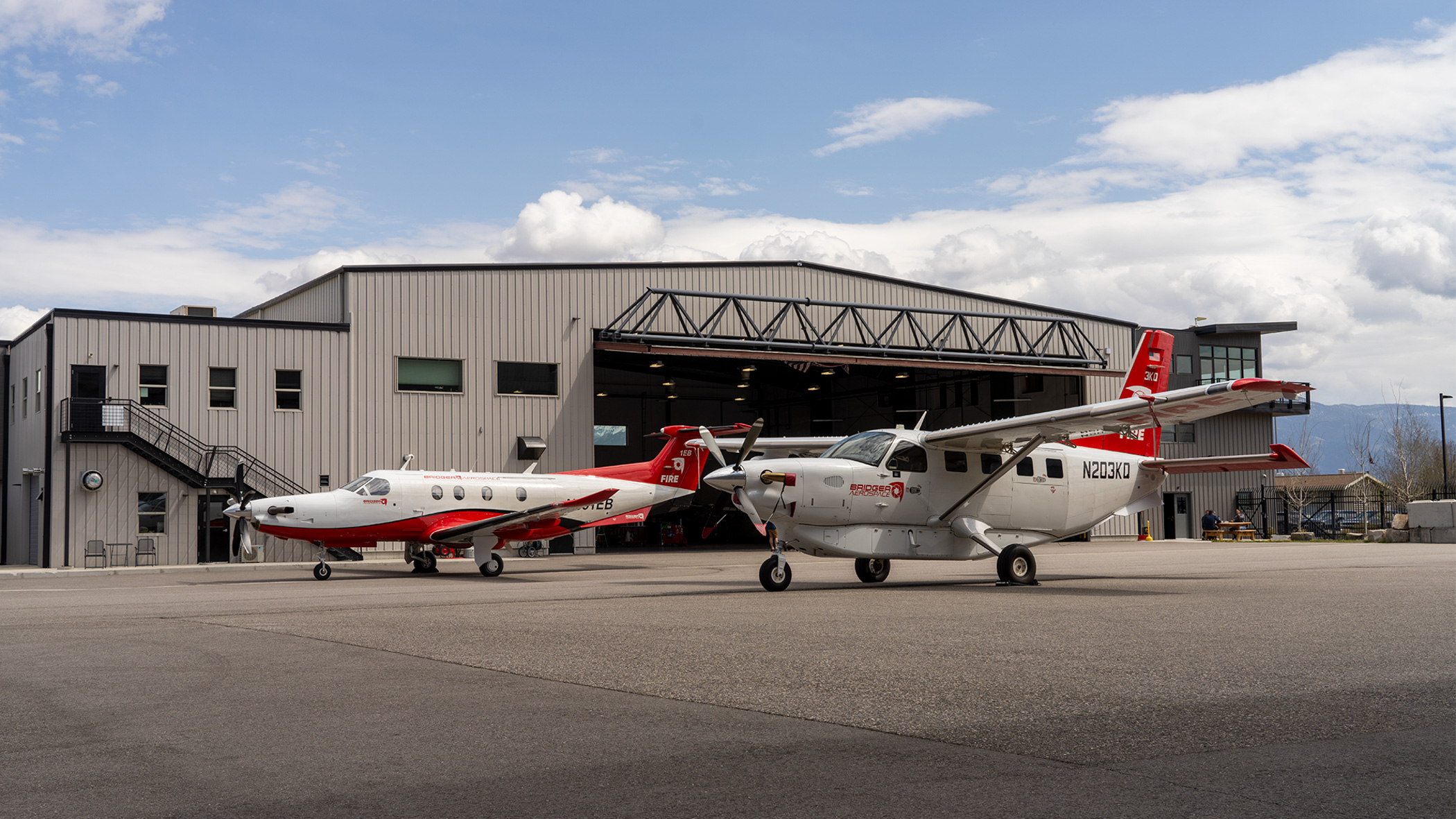 two planes in front of an airplane hanger at Bozeman-Yellowstone International Airport